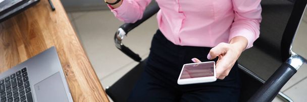 Жінка в офісі показує банківську картку і дзвінки по телефону
 - Фото, зображення