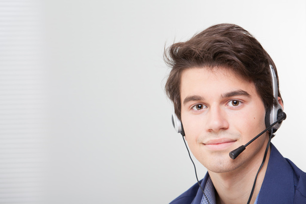 πορτρέτο του ένα χαμογελαστό κλήση κέντρο εργαζομένων φορώντας ακουστικά - Φωτογραφία, εικόνα