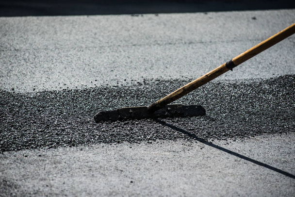 asfalt leggen nieuwe werknemers met gereedschap - Foto, afbeelding