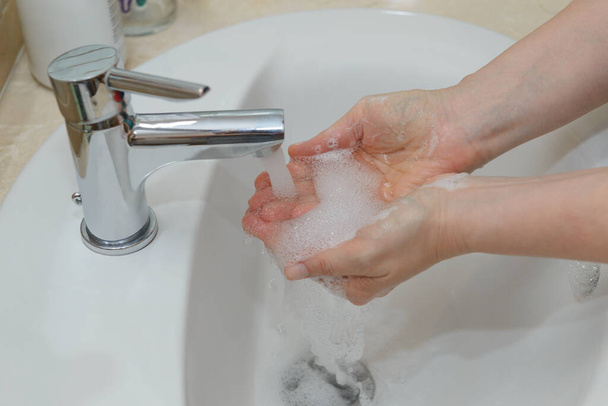 widok żeńskich rąk w piance mydlanej pod kranem zbliżenie wody - Zdjęcie, obraz