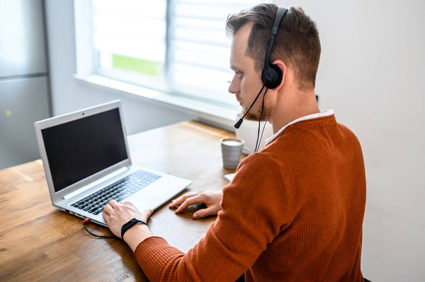 The guy uses hands-free headsets to work from home - Photo, image