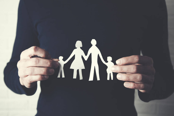 hands holding a paper cutout in the form of a family - Photo, Image