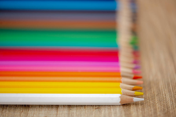 Nahaufnahme von Regenbogen-Buntstiften auf natürlichem Holz-Hintergrund - Foto, Bild