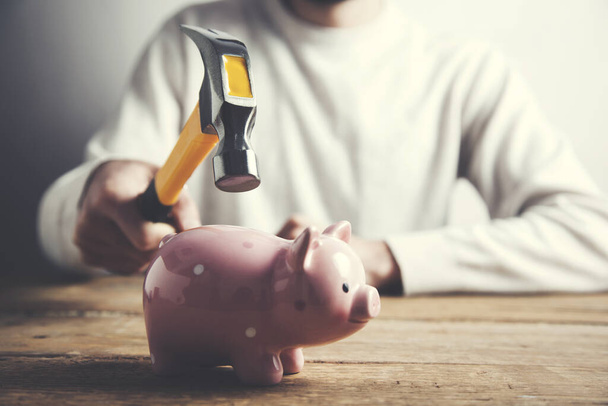 A hand holding a hammer which is raised  piggy bank - Photo, Image