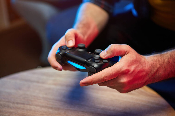 Gamer tenant la manette de jeu, le contrôleur ou la console de manette de jeu vidéo dans les mains. Gros plan, concept de jeu
 - Photo, image