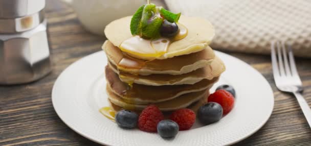 Food and Cooking Concept. Stack of pancakes with berry and warm maple syrup in slow motion - Footage, Video