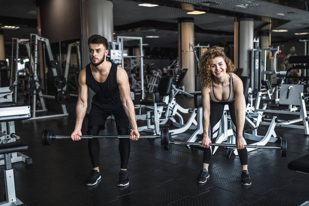 Fitness und junges Paar trainieren im Fitnessstudio mit Langhantelgewichten. - Foto, Bild