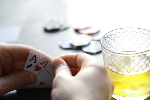 お金のためのギャンブルカードゲーム。テキサスホールデムポーカー.手札、チップの演奏、ガラスの中のアルコールのカードのデッキ. - 写真・画像