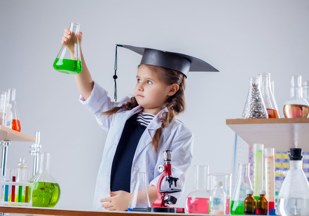 Serious chemist looking at reagent in flask - Photo, image