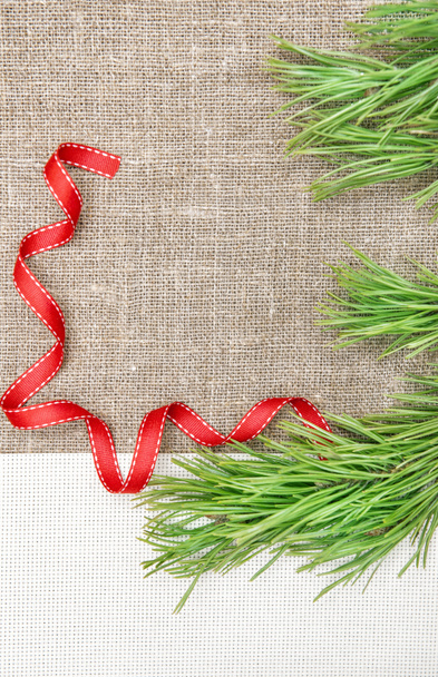 Різдвяна листівка з полотном, ялинкою та стрічкою на мішковині
 - Фото, зображення
