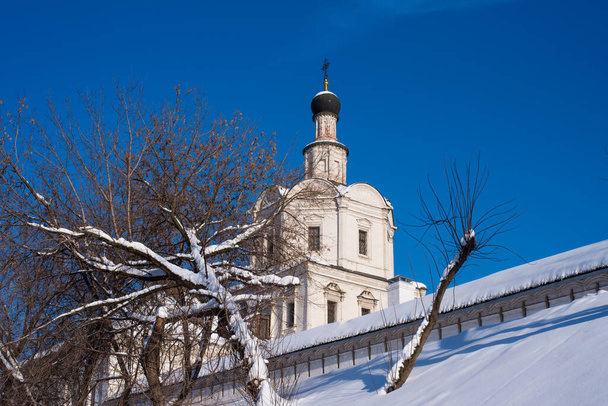 Kirche und Klostermauer vor blauem Himmel im Winter - Foto, Bild