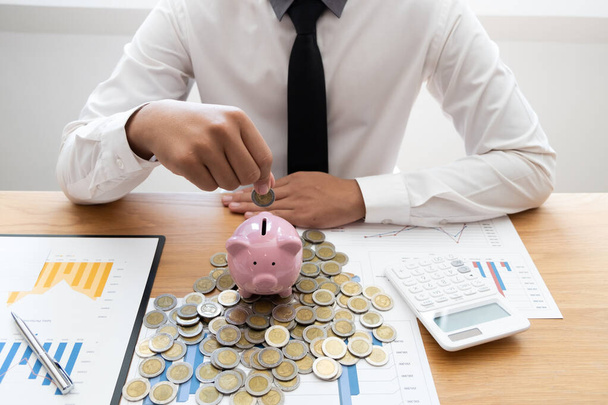 Επιχειρηματίας βάζοντας κέρμα σε γυάλινη φιάλη για εξοικονόμηση χρημάτων, οικονομική, λογιστική έννοια. - Φωτογραφία, εικόνα