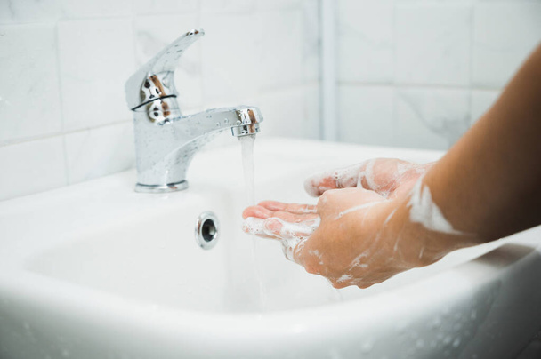 Fermer Mains masculines se lavant les mains avec du savon. pour la prévention du virus corona
. - Photo, image