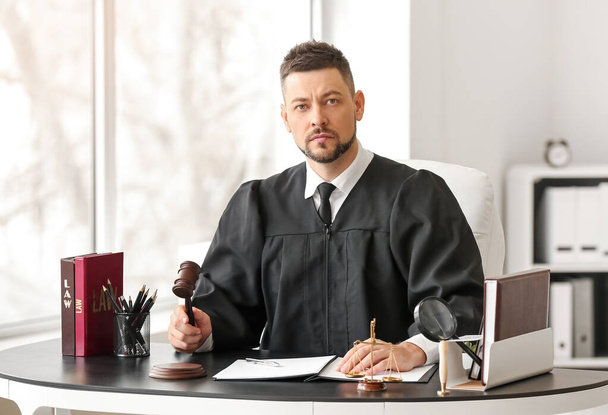 Чоловік суддя працює за столом в офісі
 - Фото, зображення