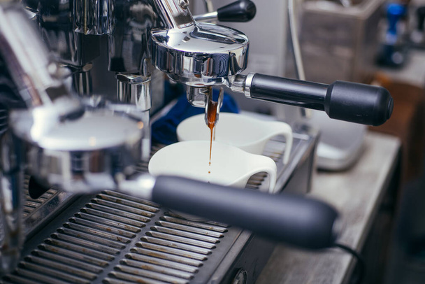 Preparation of two espresso in coffee machines.Professional coffee machine making espresso in a Two cafe - Foto, afbeelding