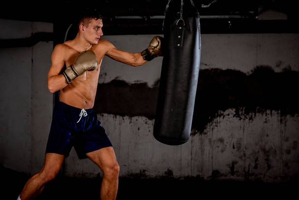 Concept d'un mode de vie sain.Jeune athlète combattant pratique coups de pied avec punching bag.Kick boxer boxe comme exercice pour le combat
 - Photo, image