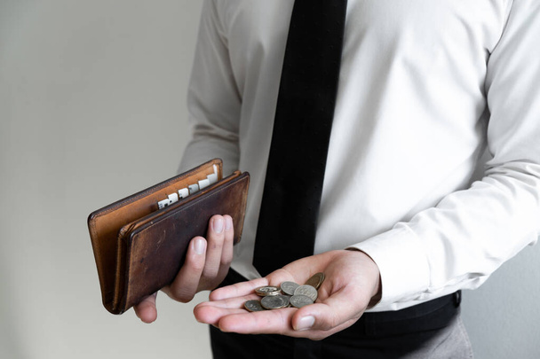 Üzletember kezében pénz és barna pénztárca, tartalék pénz koncepció. - Fotó, kép