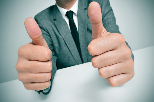 man in suit giving a thumbs up signal - 写真・画像