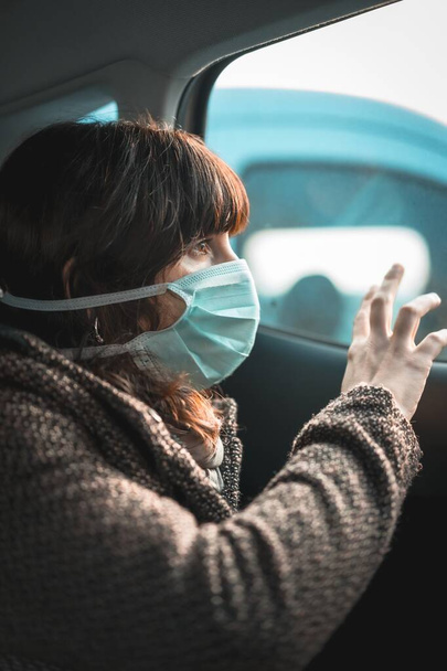 Una donna che indossa una maschera medica dall'aspetto triste-concetto di coronavirus - Foto, immagini