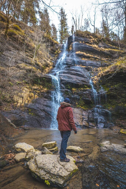 A person standing in front of the waterfall in the forest in Spain - Fotó, kép