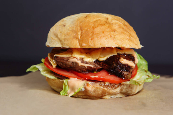 Saftiger Burger mit Hühner- und Lammfleisch auf dunklem Hintergrund - Foto, Bild