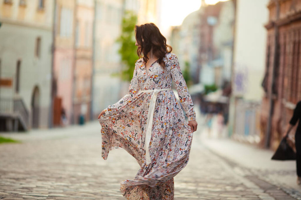 Beautiful girl walking on the street in spring. Young woman enjoying spring weather weather - Photo, Image