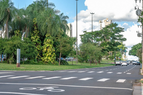 Avenida unidireccional con cuatro carriles, gran avenida boscosa con poco tráfico de coches. Avenida Afonso Pena en Campo Grande MS, Brasil
. - Foto, imagen