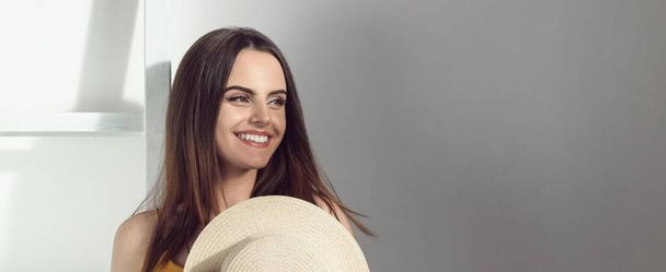 Panoramic shot of pretty girl smiling and holding a hat with copy space - Fotografie, Obrázek
