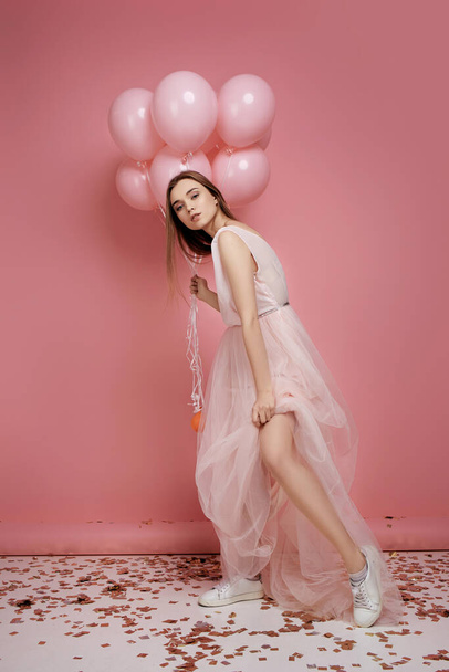 fashion model woman in dress holding pastel pink air balloons - Fotoğraf, Görsel
