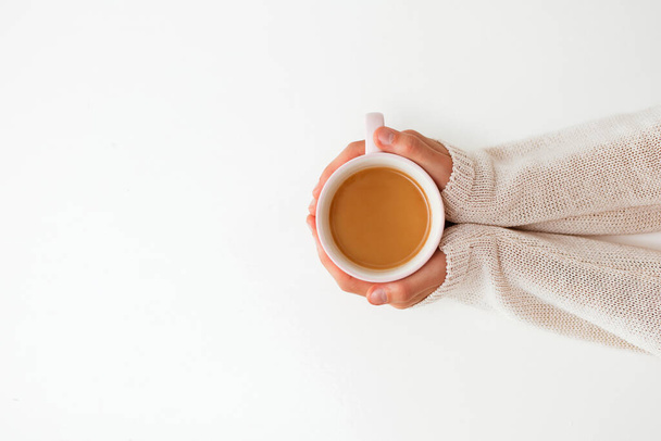 Női kéz kezében csésze kávé fehér asztal háttér - Fotó, kép