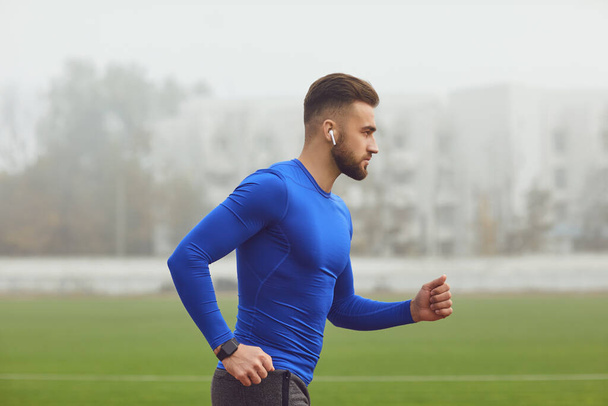 Athletic man runs in training at the stadium. - Fotoğraf, Görsel