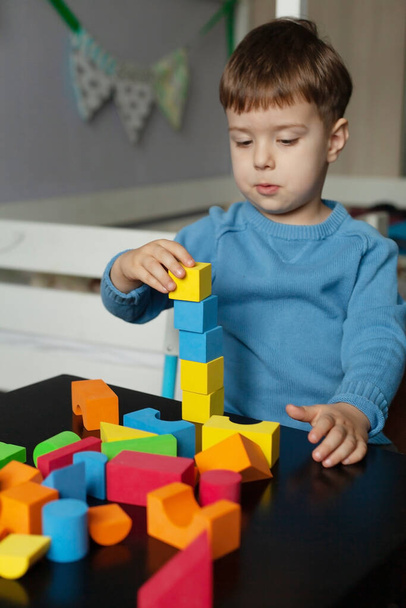 Creative boy playing with colorful cubes Little child playing at home. Educational games for preschool children - Foto, Imagen