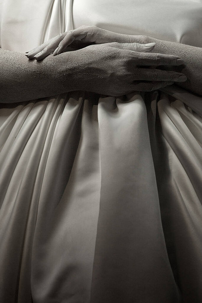 Тело живой скульптуры молодой женщины, ее руки на беременном животе
 - Фото, изображение