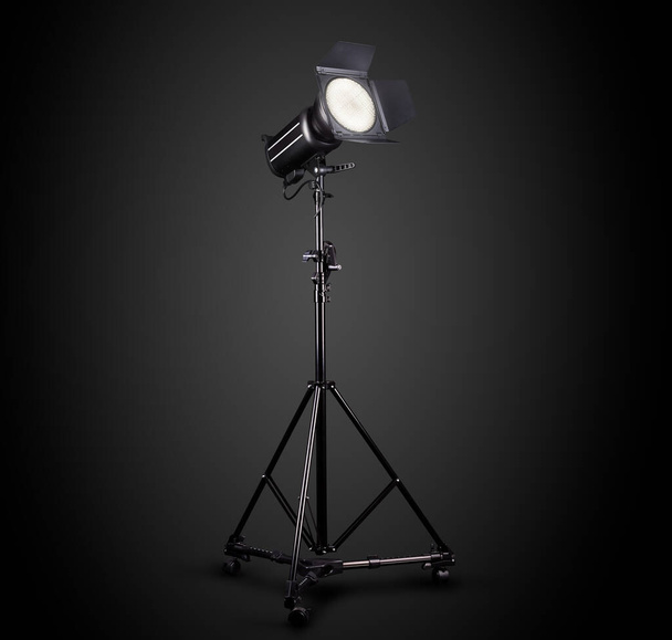 Fotografie studio flitser op een lichtstandaard geïsoleerd op zwarte achtergrond. - Foto, afbeelding