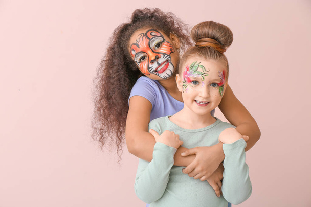 Niños divertidos con pintura facial sobre fondo de color - Foto, Imagen