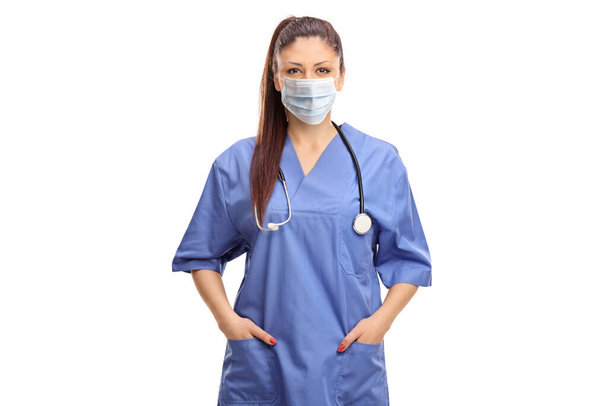 Female doctor in a blue uniform and a medical face mask isolated on white background - 写真・画像
