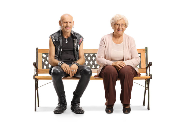 Bald punk with an elderly woman sitting on a bench and smiling at the camera isolated on white background - Photo, image