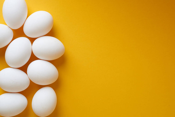 Eggs on a yellow background. Smooth beautiful eggs, space for text.Minimalism. The view from the top. - Valokuva, kuva