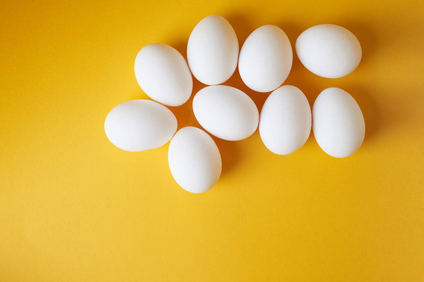 Eggs on a yellow background. Smooth beautiful eggs, space for text.Minimalism. The view from the top. - Photo, Image