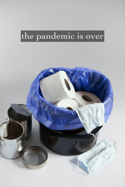 Pandemie is voorbij concept. Het einde. Stop het coronavirus. Prullenbak gevuld met wc-papier en medische maskers .coronavirus controle. na een coronaviruspandemie. einde van de quarantaine - Foto, afbeelding