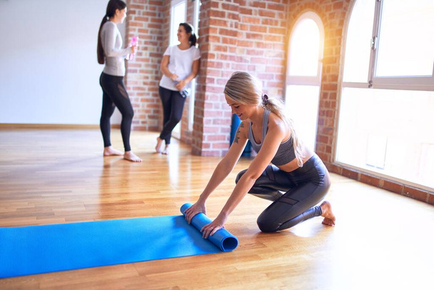 Jeune belle sportive utilisant tapis de sport pour pratiquer le yoga à la salle de gym
 - Photo, image