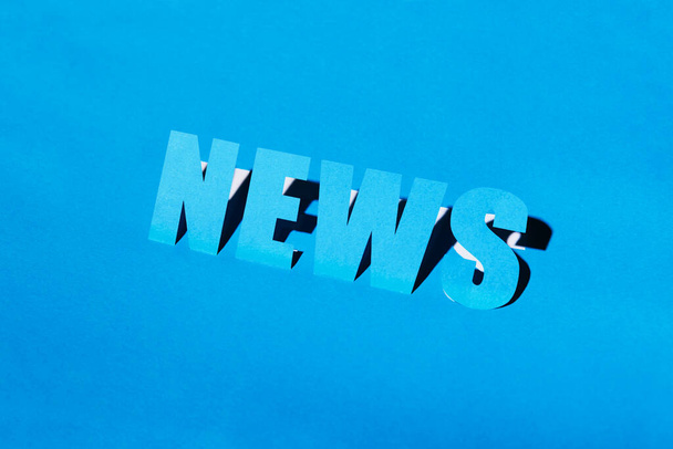 The inscription News on a blue background cut out of paper. paper letters - Фото, изображение