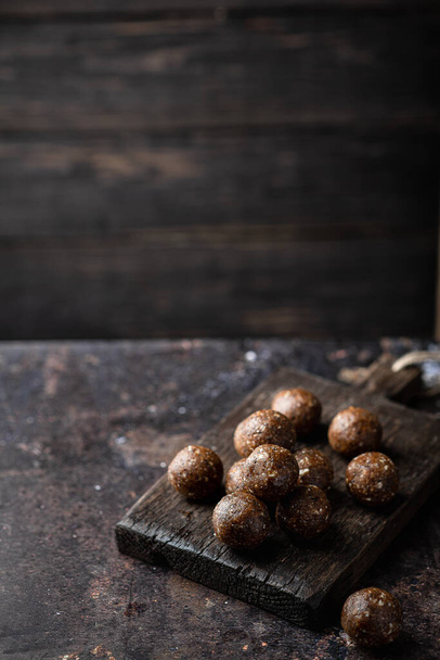 homemade chocolate sweets from nuts, dried fruits and cocoa on a dark background. Place for text - Fotoğraf, Görsel