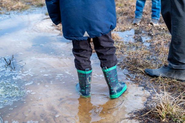 bright rubber boots in a puddle - Fotó, kép