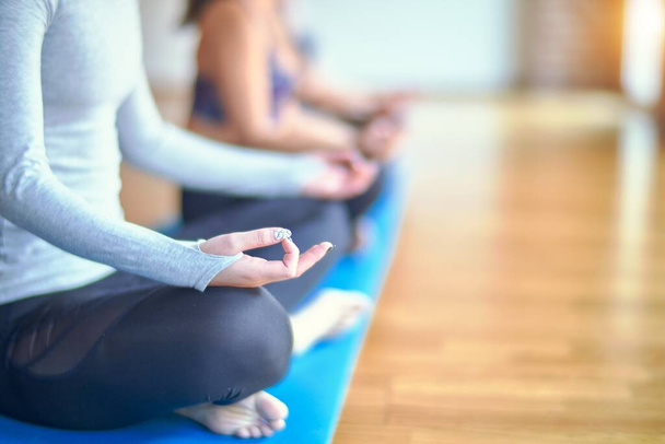 junge schöne Gruppe von Sportlerinnen, die Yoga praktizieren. Lotus posieren im Fitnessstudio - Foto, Bild