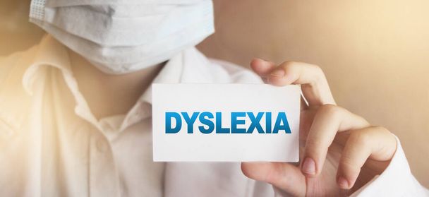 Dyslexia word on card. Doctor keeps a card with the name of the diagnosis dyslexia. Selective focus. Medical concept. - Foto, Imagen