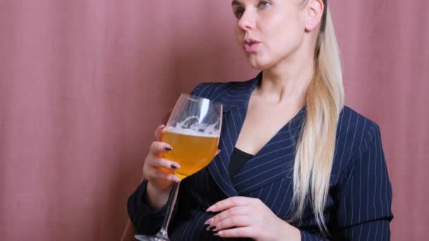 Alcohol femenino para una joven rubia sosteniendo vino burbujeante, cerveza. Mujer relajante después del trabajo bebiendo vino en la cocina
 - Metraje, vídeo