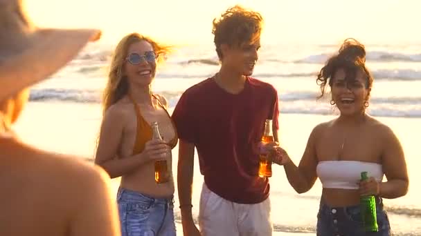 trzy osoby spotykają się z przyjaciółką na plaży i cieszą się, że ją widzą - Materiał filmowy, wideo
