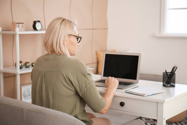 Dojrzałe kobieta za pomocą laptopa do nauki online w domu - Zdjęcie, obraz