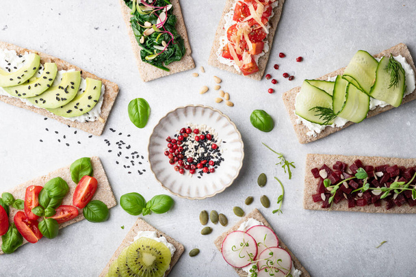 Different kinds of vegetarian sandwiches on a light background. Top view, place for text. - Fotografie, Obrázek